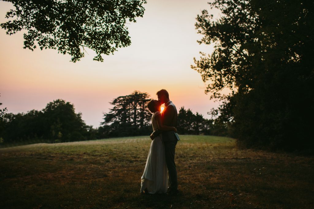 couple qui s'embrasse devant un coucher de soleil au Domaine de Peyreguihot