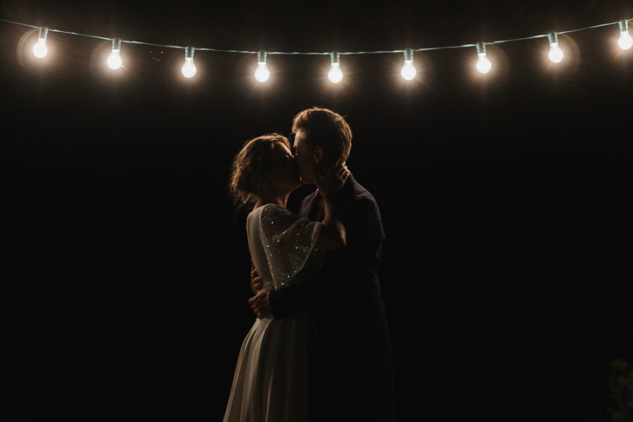 couple qui s'embrasse sous une guirlande lumineuse en Dordogne