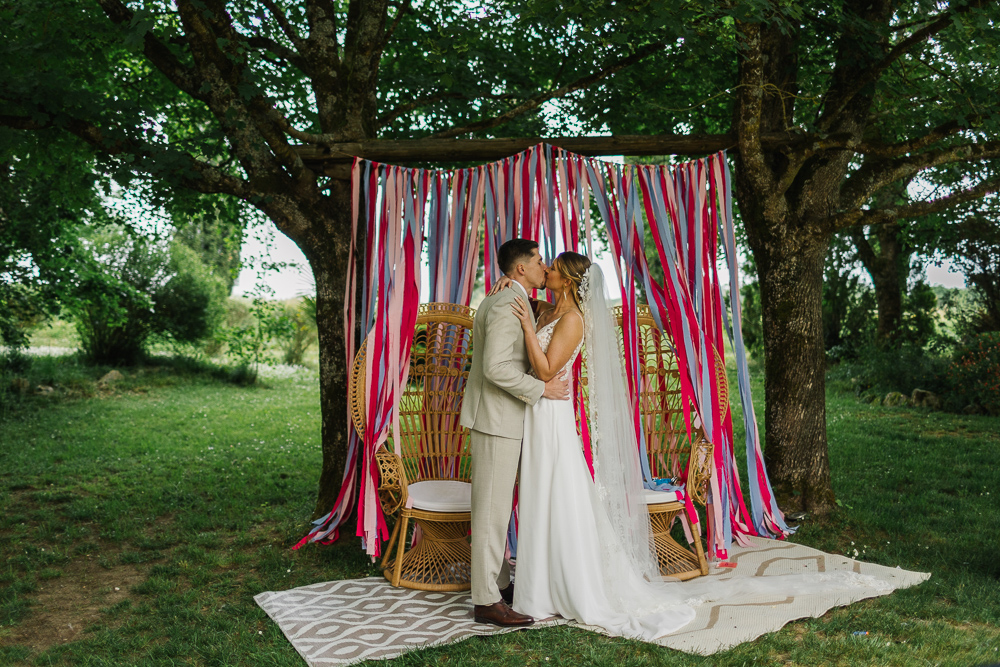 couple mariage champêtre qui s'embrasse pendant la cérémonie laïque